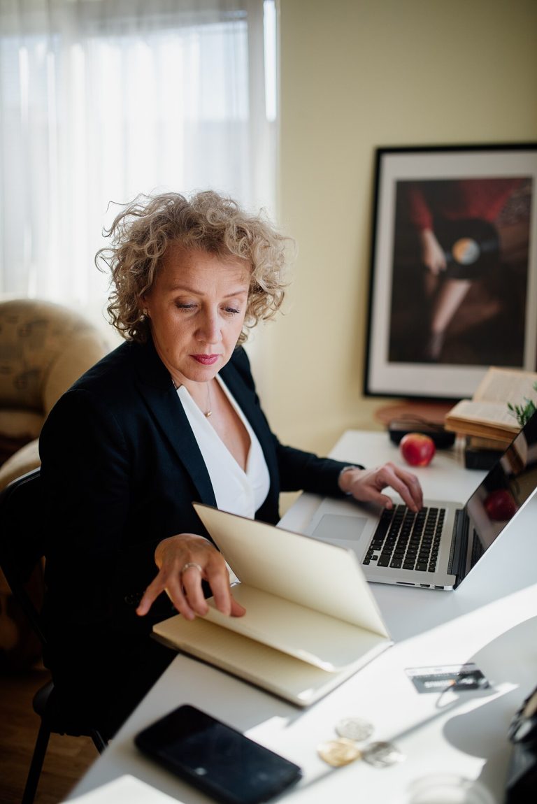 Download SlideShare Presentations to Study and Work Offline Professional woman reviewing documents and working on a laptop at her desk